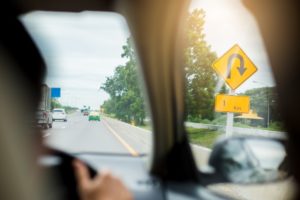 Driver seeing UTurn sign ahead.