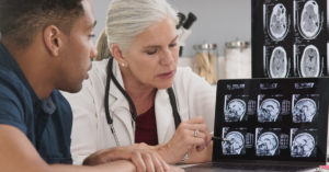 Doctor explaining ct scan result of brain injuries to patient.