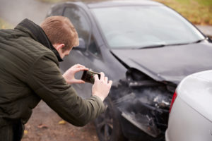 Driver collecting evidence from a car accident.