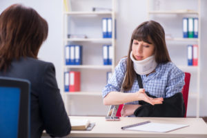 An injured woman speaking with a workers' comp lawyer in GA about her claims.