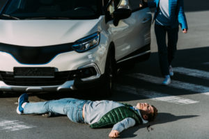 Injured pedestrian lying on the road in Athens after being hit by a car.