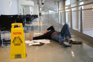 A man having a slip and fall accident on a wet floor.