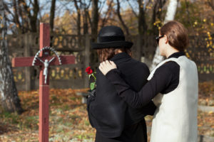 Two women grieving following loss of family member who was killed on the job.
