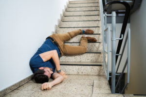 Unconscious man lying on staircase after slip and fall accident.