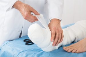 doctor bandaging leg of a patient