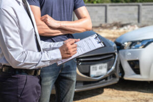 Insurance adjuster checking on damage cars.