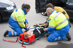 Paramedics rescuing car accident victim.