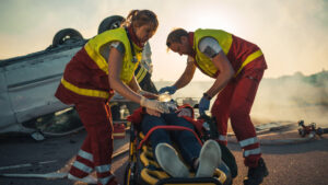 Paramedics rescuing victims from car accident who are severely injured.