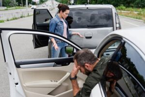 Female driver checking for damage car from accident.