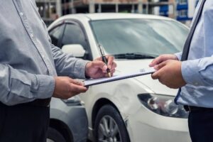 Insurance agent checking damages from car accident.