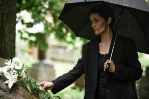 Widow visiting late husband at cemetery.