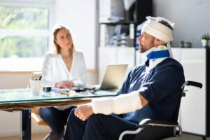Injured employee on wheelchair filing for workers compensation claim benefits.